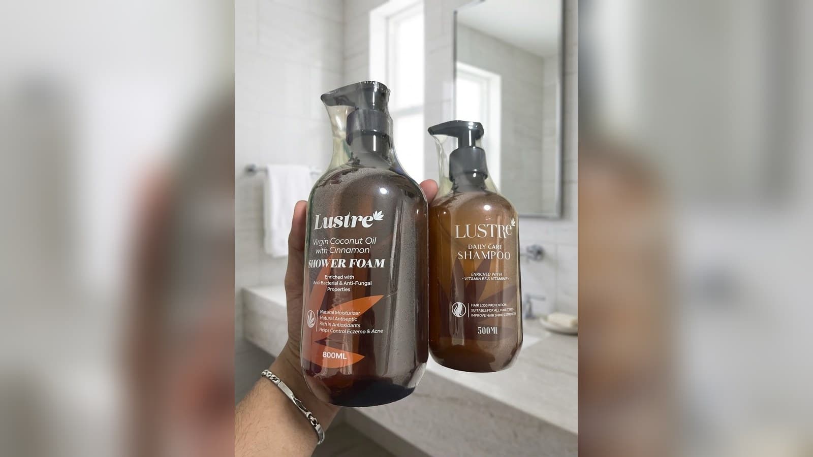 Lustre Shower Foam and Lustre Daily Care Shampoo bottles from Singapore brand MyLustre, held up in a bathroom