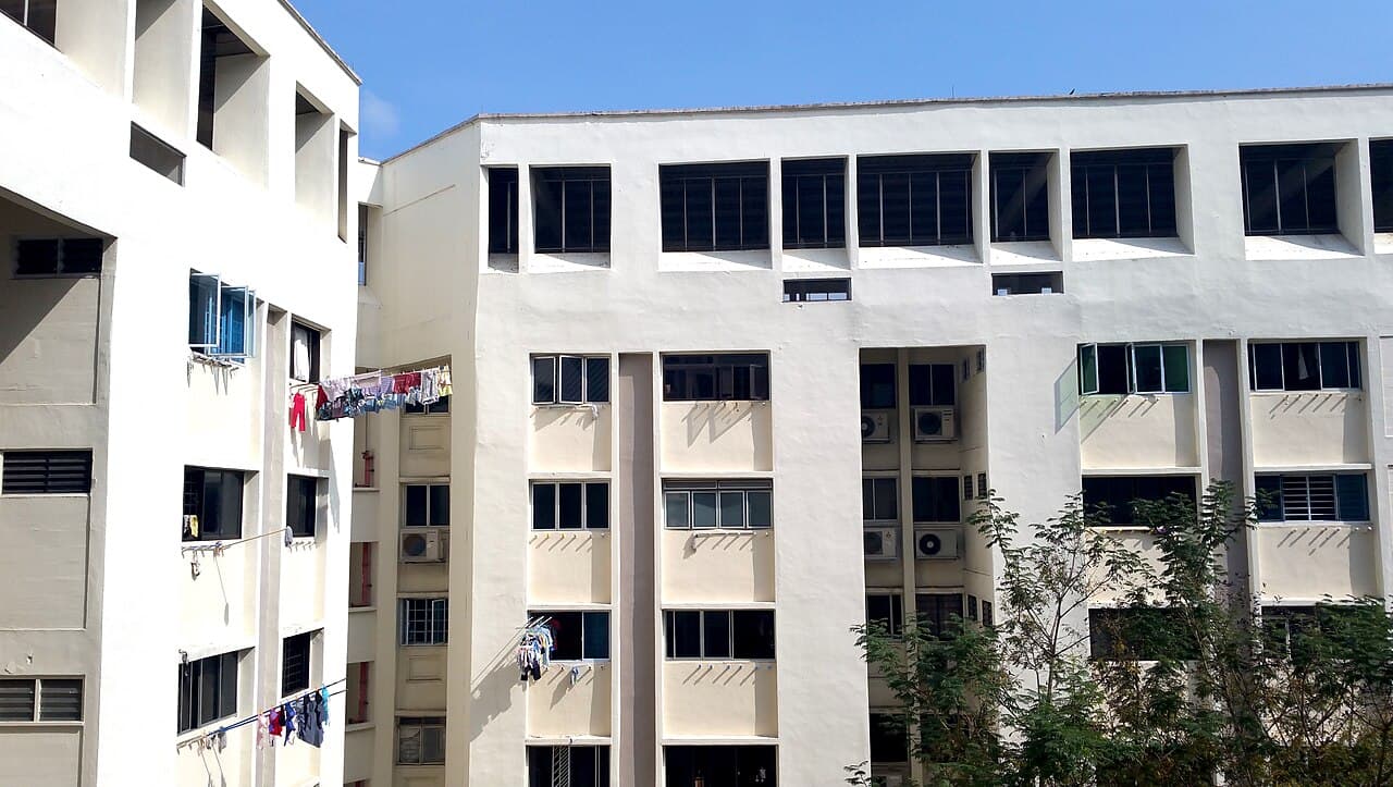 Singapore HDB blocks with laundry poles under a clear sky, illustrating which households qualify for Budget 2026 payouts and U-Save rebates