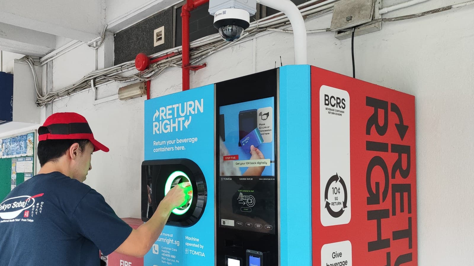 A man returns a bottle at a Return Right reverse vending machine in Singapore