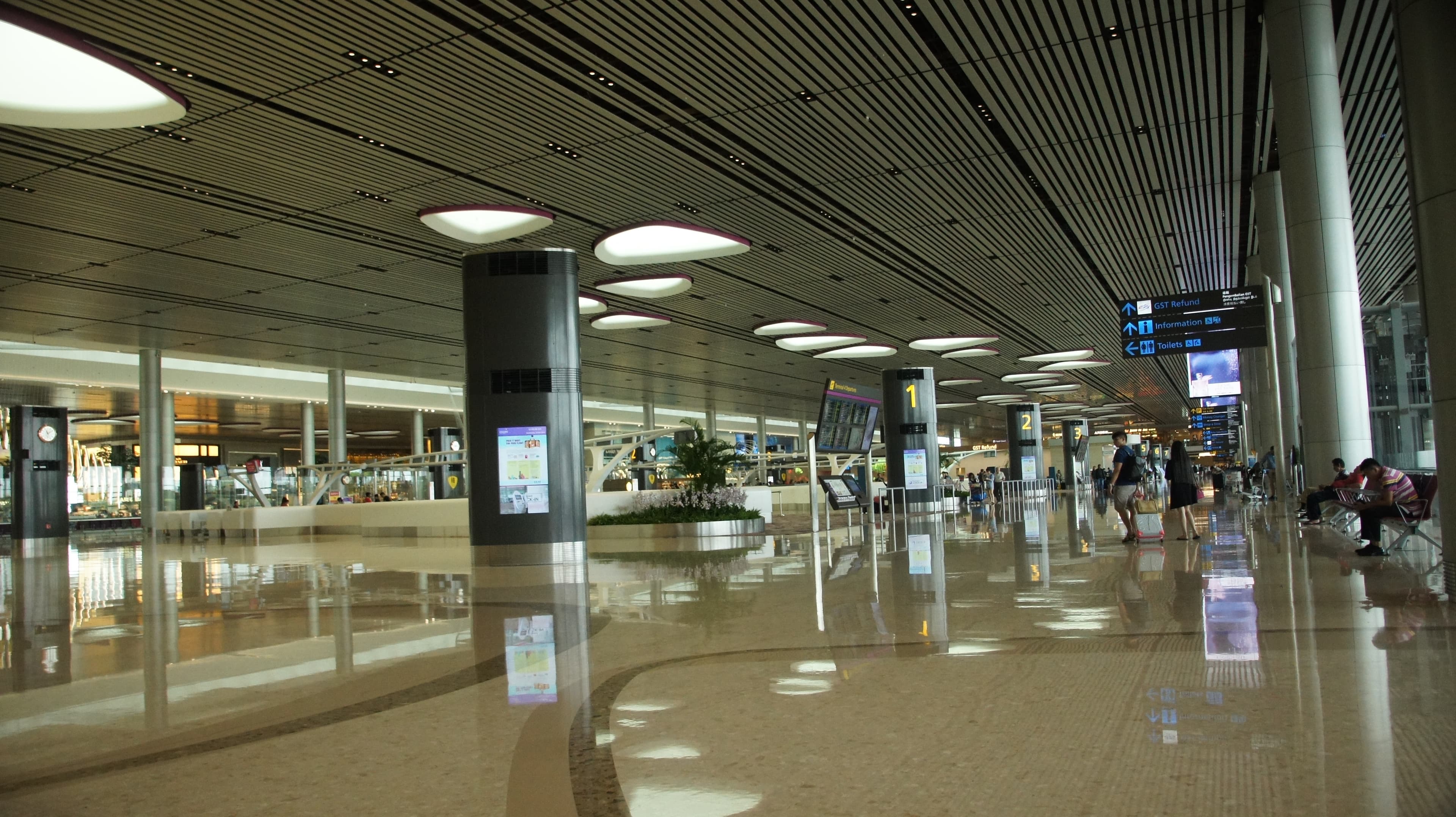 Travellers and check-in counters inside a bright Changi Airport departure hall