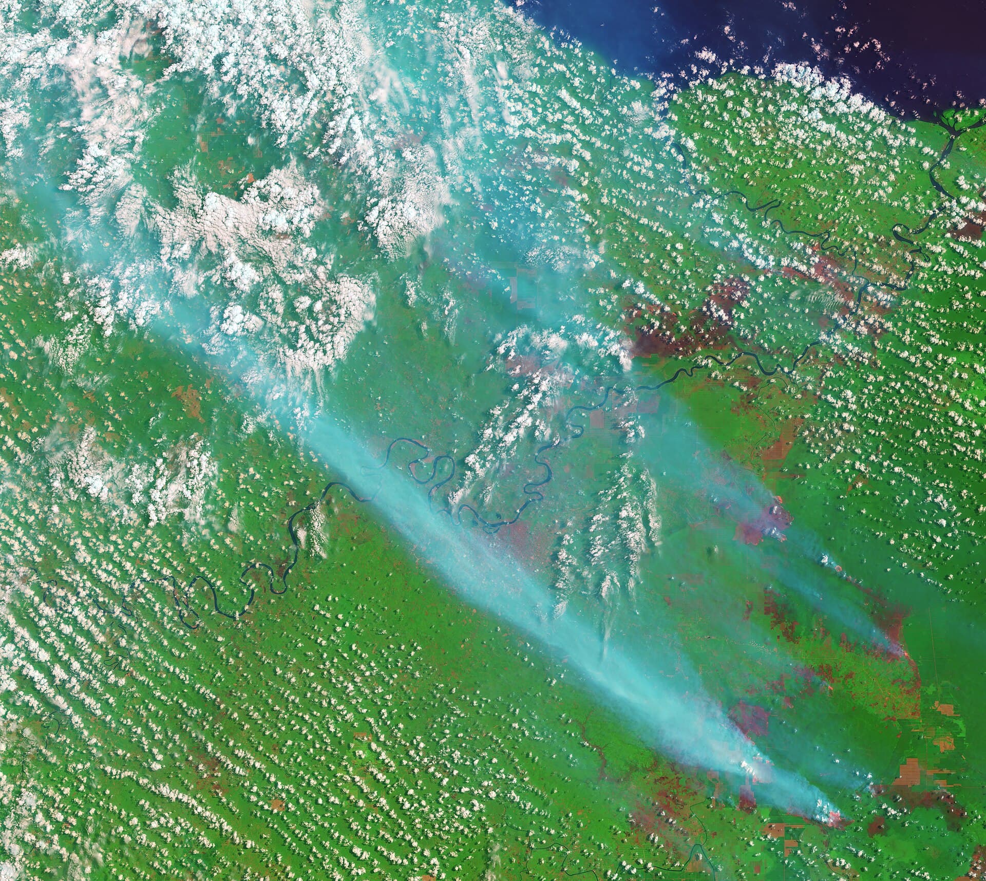 Satellite view of pale smoke plumes rising from fires in Sumatra and drifting across the region, the source of Singapore's haze.