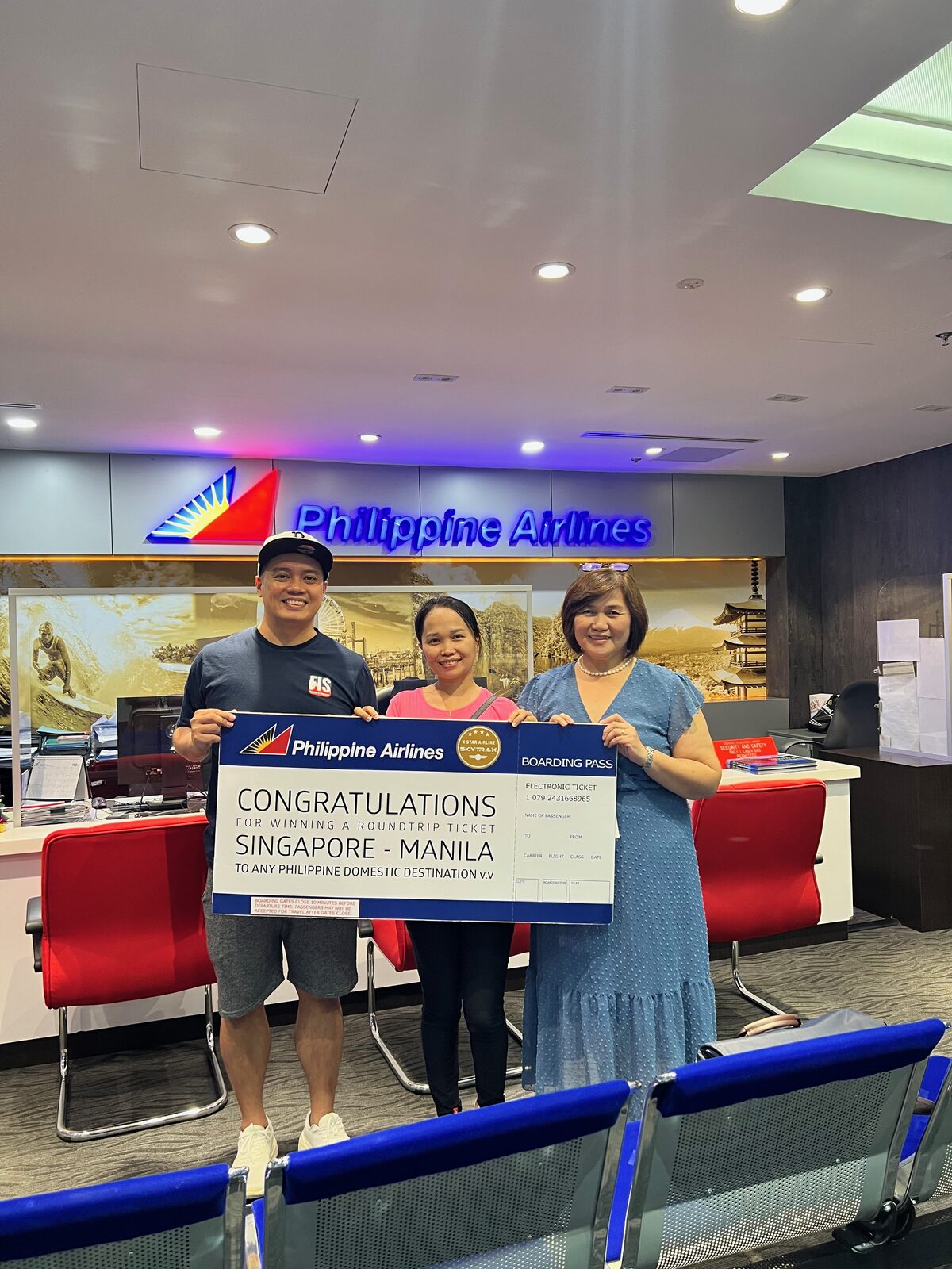The FIS Editorial team and the Wishing Tree winner with the Philippine Airlines Singapore staff at the PAL office on Selegie Road, holding the Singapore–Manila roundtrip boarding-pass display