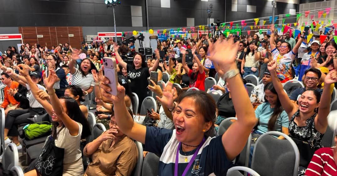 Fiestang Pinoy 2026 crowd cheering with hands raised and phones out during the stage programme at Suntec Singapore