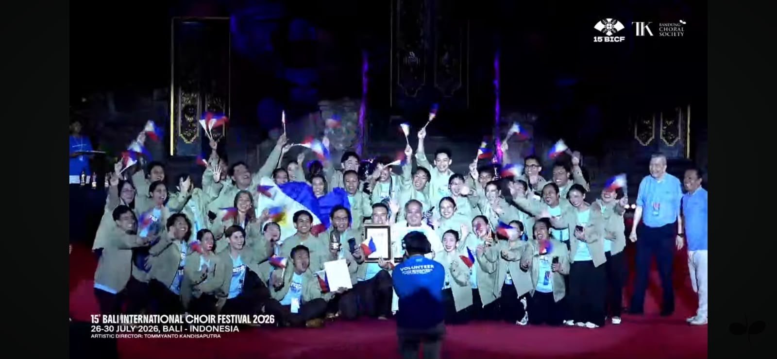 The Transfiguration Music Ministry Singers on stage at the awarding ceremony, waving Philippine flags